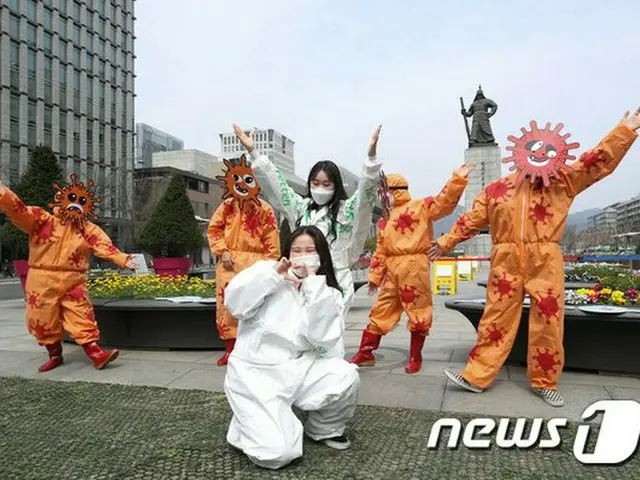 Seorang anggota Seoul Citizen Hygiene Centre Seoul menyerukan bernyanyi dan mena