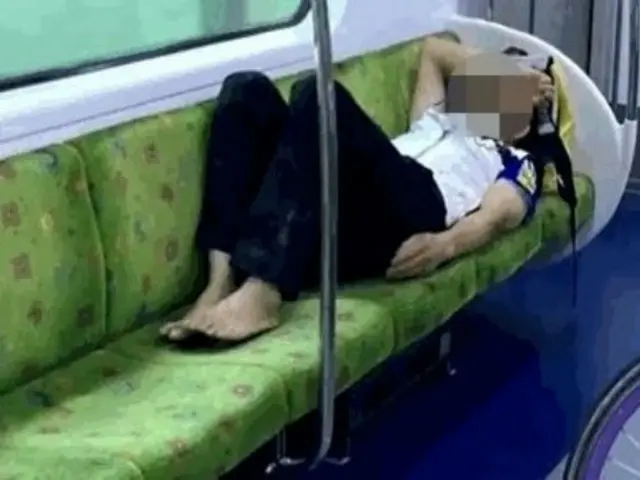 Pria Korea Selatan tidur tanpa alas kaki sambil menempati empat kursi di kereta bawah tanah