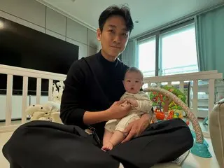 Aktor Joo Ji Hoon tersenyum saat menggendong putri sahabatnya Jang Su-won (SECHSKIES)