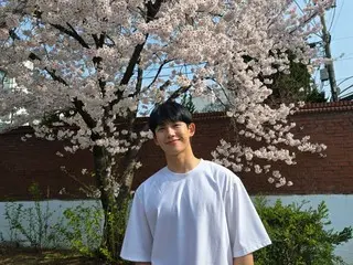 Aktor Jung HaeIn tersenyum dengan bunga sakura di latar belakang... “Saya harap akhir pekan Anda menyenangkan”