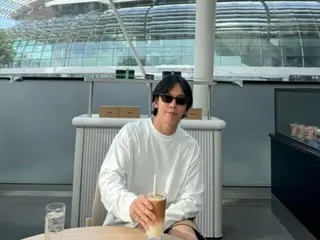 Jung Yong Hwa CNBLUE menikmati es latte dengan latar belakang Marina Bay Sands